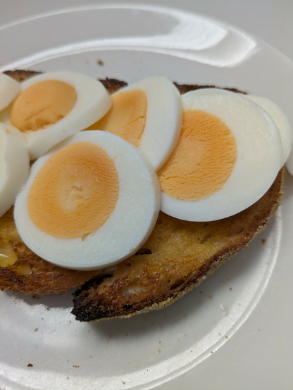 A sliced hard boiled egg on corn bread toast