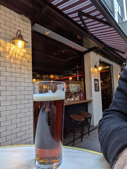 A glass of amber ale in an alley way bar
