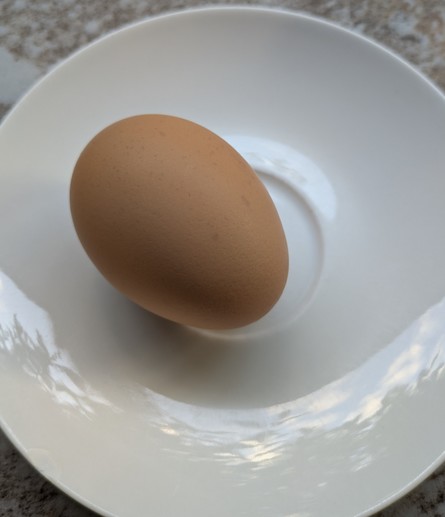 A hard boiled egg on a saucer